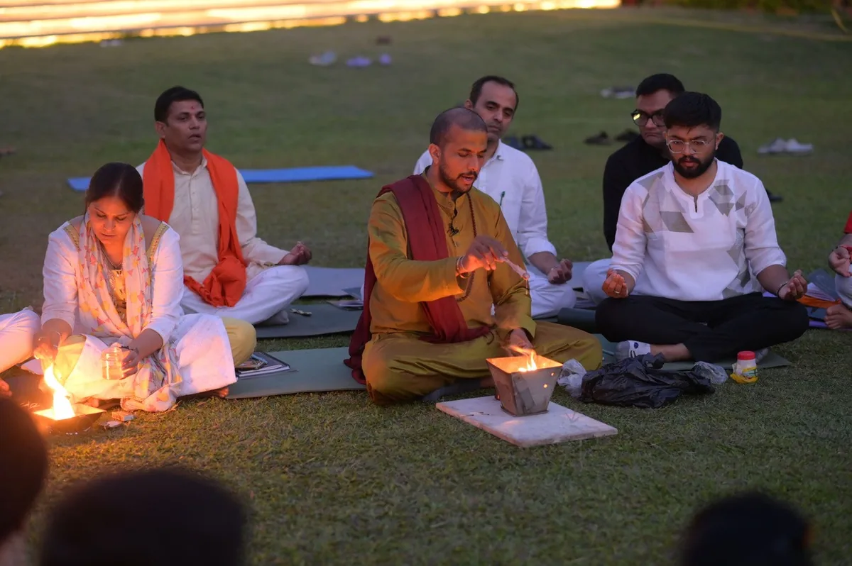 Participants seated around a fire ritual at an evening session