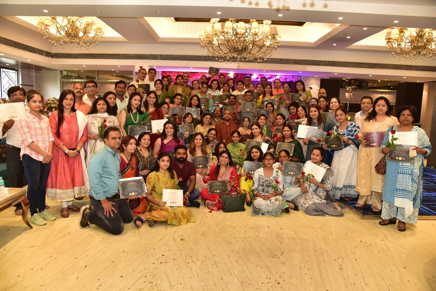 Participants holding certificates in a group photo
