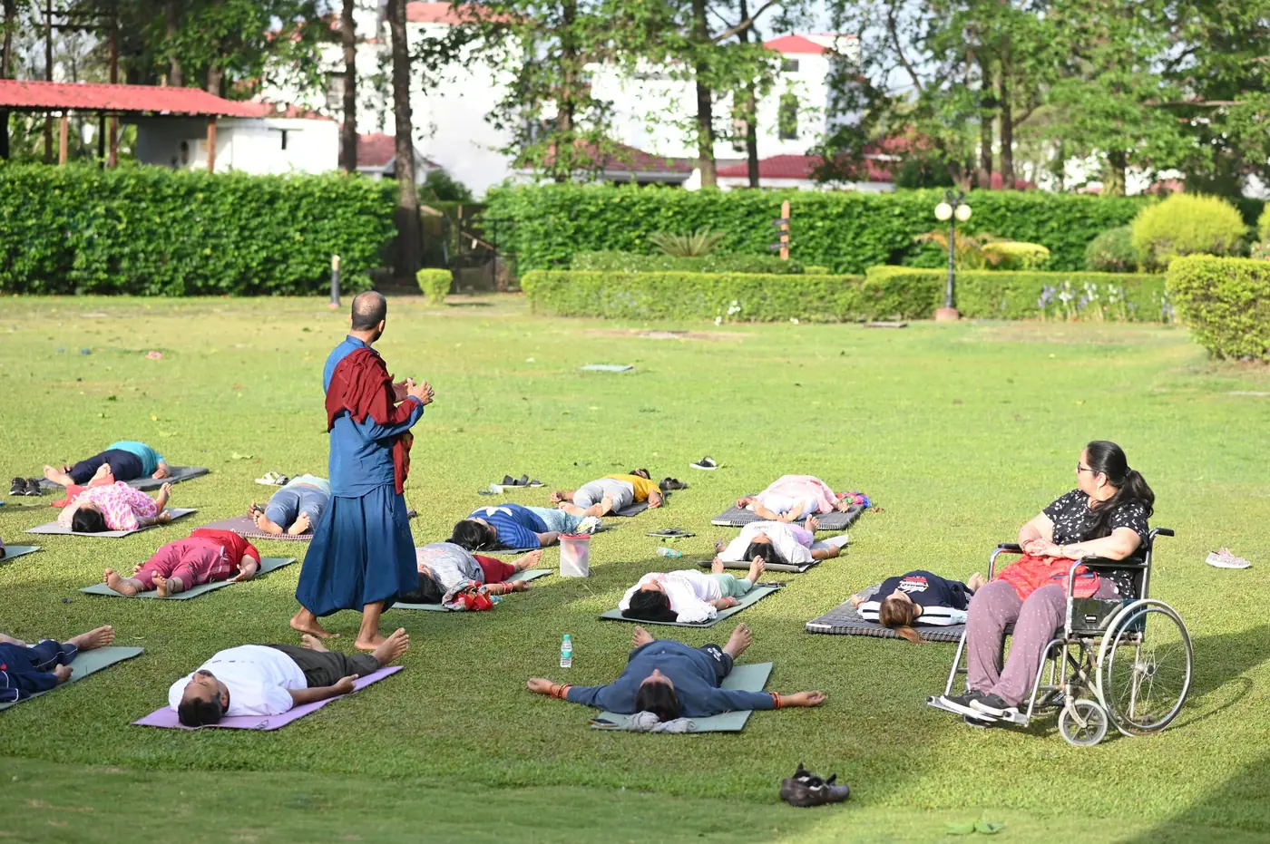 Ashishh L Vyas guiding a group relaxation session outdoors on the lawn
