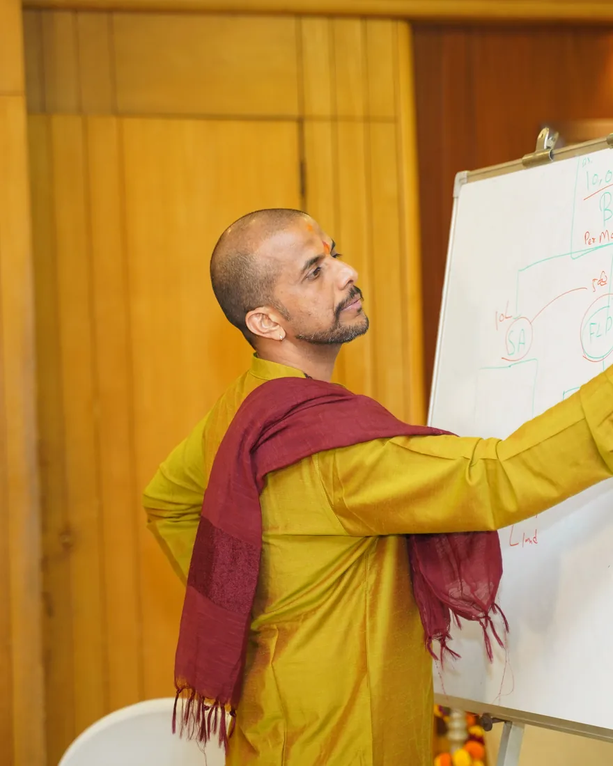Ashishh L Vyas drawing a chart on the whiteboard at a numerology workshop